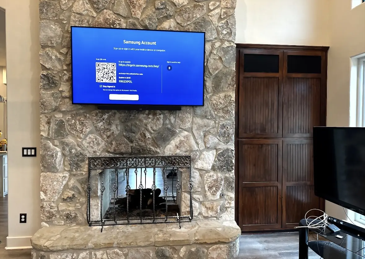 Large rubble-stone fireplace with a TV and soundbar mounted flush to the stone